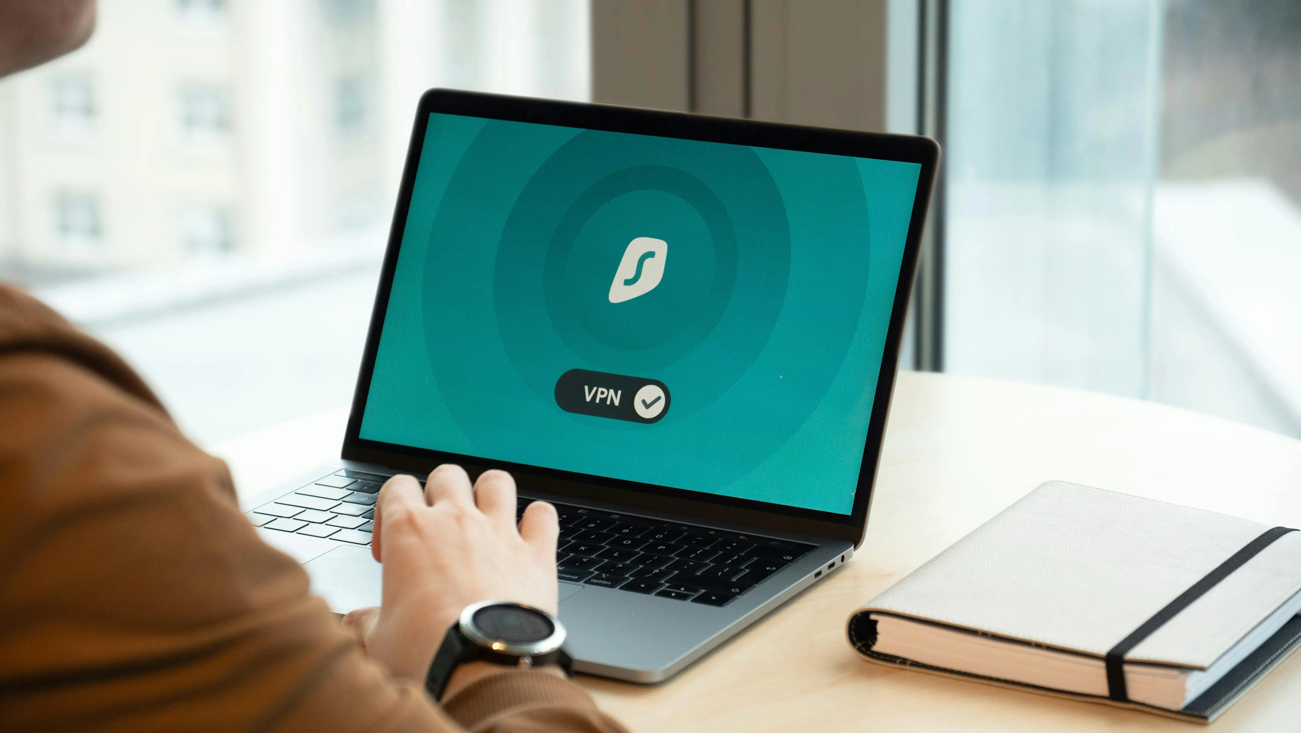 A person using a laptop and connecting to a vpn service.